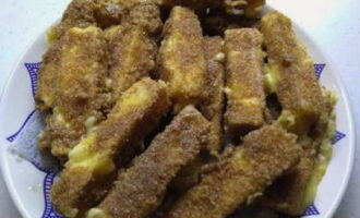 В хорошо разогретую сковороду налить растительное масло, выложить заготовки и обжарить их 15 секунд, чтобы сыр не успел растекаться. Эту закуску нужно подавать в горячем виде.